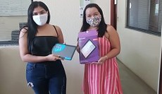 Tablet sendo entregue a aluna pela Chefe do Departamento de Ensino, Rosenete Pereira