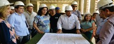 Gestores observam atentamente planta da obra